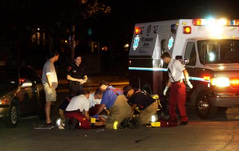 An injured female lays at the northwest corner of Fourth Street and Gregory Drive on Saturday night. The car to the left of the victim was involved in the accident which reportedly took place when the victim was running on Gregory Drive. Online Poster
