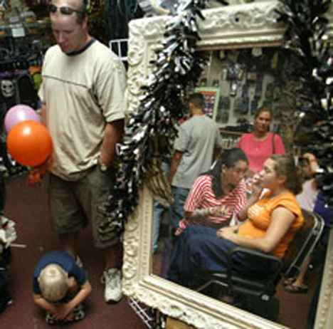 Customers of Dallas & Co., 101 E. University Ave., Champaign, wait in line for face painting as Brittany Nelson, 12, has her face painted by M.J. Kim of Champaign. Online Poster
