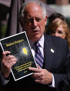 Lt. Gov. Pat Quinn holds up a copy of the Energy Task Force report recommending energy policies for Illinois in front of The Great Impasta in Champaign on Thursday. Dan McDonald
