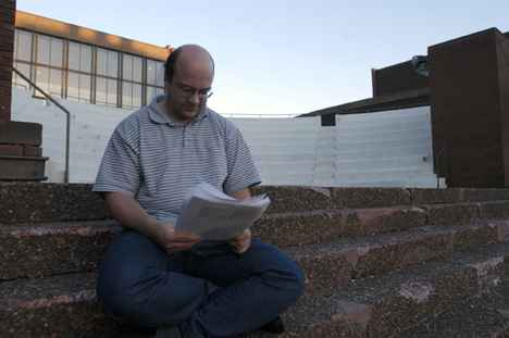 Stefan Mayer, a visiting assistant professor from Germany, reads as the sun sets Tuesday evening on the steps outside of the Krannert Center for Performing Arts. Mayer said he was continuing research at the University. Alex Nowak
