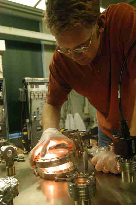 Graduate student Matt Coventry replaces the porthole on his Ion-surface InterAction eXperiment (IIAX) in Nuclear Radiation Lab on Wednesday. The experiment tests plasma-surface interactions in a controlled fusion. Online Poster
