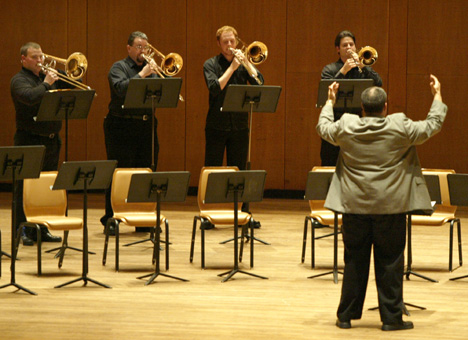 Professor Elliot Chasanov conducts the UI Trombone Choir in the Foellinger Great Hall at the Krannert Center, Thursday night. The Choir preformed pieces by Beethoven, Verdi and The Beatles. Online Poster
