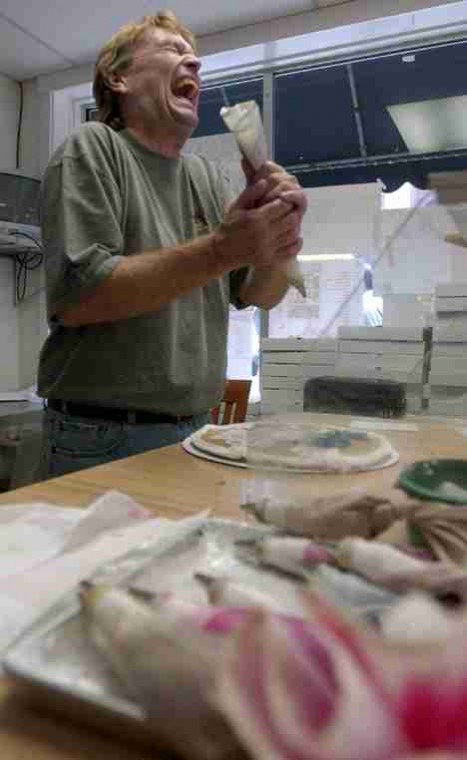 Ed Brubaker, owner of The Cookie Jar, laughs with a customer as he designs a big chocolate chip cookie on Tuesday at The Cookie Jar, 712 S. Sixth St., Champaign. Online Poster
