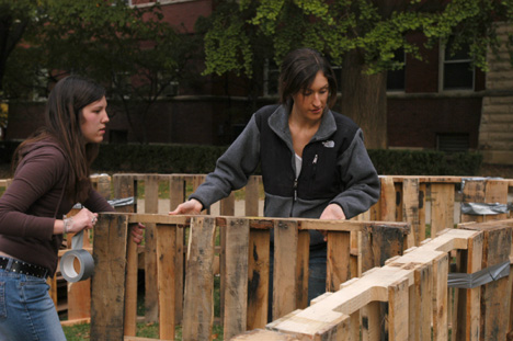Anna Lempart, left, freshman in LAS, and Tracy Siegel, sophomore in LAS, help to build the walls of a shantytown on the Quad Monday evening. Shantytown is Habitat for Humanity´s way to raise awareness of homelessness, according to local board member Carol Matteucci
