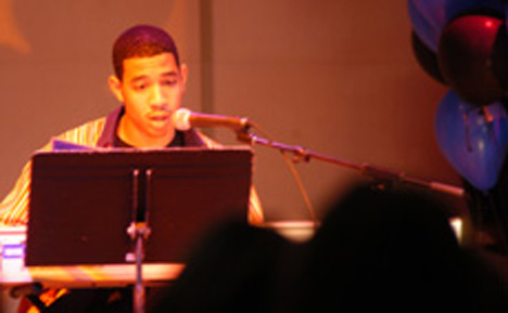 Bryan Stewart, sophomore in LAS, combines music and poetry in a performance at the AAH King and Queen Pageant for the African-American Homecoming at the Courtyard Cafe in the Union on Tuesday night. Alex Nowak
