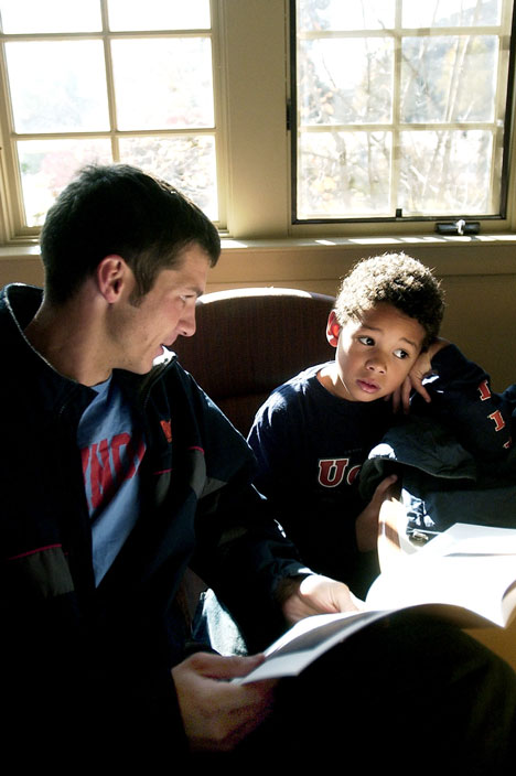 Illinois track and field member Charlie Kurlinkus, senior in LAS, reads The True Story of the 3 Little Pigs to Kevin Eadie, 6, at the Irwin Academic Center on Saturday. Kurlinkus is one of several Illinois sport team members who volunteer their time readi Online Poster
