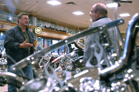 Steve Wertz, left, of St. Joseph, discusses amenities on a motorcycle he is considering purchasing with salesman Greg Lindstrom, Thursday at Andrae´s Harley-Davidson, located at 2010 N. Lincoln Ave. in Urbana. Online Poster
