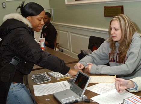 Lakisha Harvey, junior in business, gets information for Boogie Night, a dance marathon benefitting Children´s Miracle Network on Feb. 4, from Diane Kledzinski, junior in business, Tuesday afternoon in the Illini Union. People can sign up to donate Online Poster
