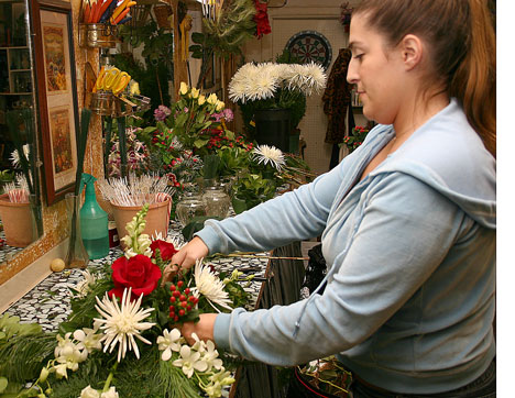 Champaign resident Erin Malloch, 24, designs a flower arrangement Thursday at Ginza Flowers, 315 E. University Ave., for a customer´s Christmas party tonight. Malloch has worked at Ginza Flowers for nine years. Online Poster
