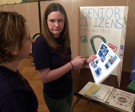Liz Rice, sophomore in ALS, left, and Stephanie Juen, junior in ACES, discuss one of the projects on display at a Volunteer Illini Projects event in the Illini Union Ballroom on Wednesday night. Tim Eggerding
