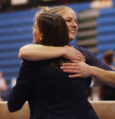Cara Pomeroy hugs assistant coach Kim Mazza after performing on the balance beam Jan. 29. Illinois lost to Denver 195.025-194.150. Online Poster
