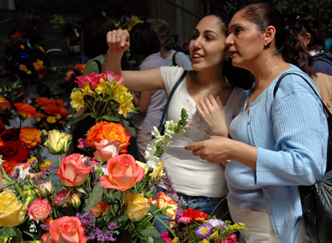 Tricia Spatafora, sophomore in LAS, inspects flowers with her mother, Carmela Spatafora, from Brookfield, Ill., on Saturday during the Mom´s Weekend Flower Show held in the Stock Pavilion. Online Poster
