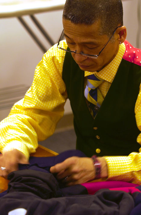 Right Hiro Hosomizu works on a jacket for Enjolras, a character in the musical Les Miserables at Assembly Hall on Tuesday. Online Poster
