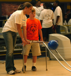 Jen Andresen (left) of Champaign helps Jason, 14, bowl at a Special Olympics bowling competition Sunday at Western Bowl in Champaign. Nick Kohout
