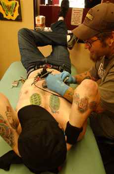 Josh Wood, 25, of Champaign completes a design on Justin McCrocklin, 24, of Urbana at Altered Egos Tattoo Shop in Champaign on Sunday. Tessa Pelias
