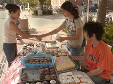 Catalina Ferro (left), junior in applied life sciences, buys a cupcake Tuesday afternoon from Sandra Hong, sophomore in LAS, and Henny Lee, freshman in LAS. Proceeds from the bake sale benefitted hurricane victims on the Gulf Coast. Nick Kohout

