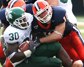 Illinois´ defensive back Kyle Kleckner tackles Michigan State´s Jehuu Caulcrick on Saturday at Memorial Stadium. Illinois lost to Michigan State, 61-14. Josh Birnbaum
