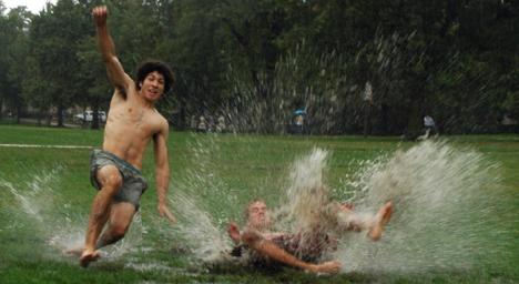 Freshmen Matt Landig (Left), LAS, and Brian Durbin, Business, mud slide on the quad in the pouring rain Thursday. Vadim Olen
