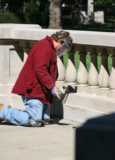 Mike Eades of White Heath cuts out caulk along the porch in front of Foellinger Auditorium. Adam Babcock

