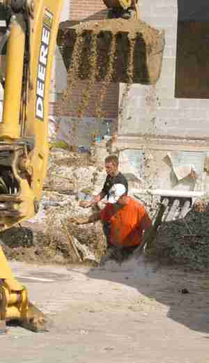 Bryan Youngblood, Sidney resident, front, and Marcus Alben, resident of Champaign, dodge falling dirt from a backhoe while installing an electrical line on the corner of Lincoln and Nevada Wednesday. Ben Cleary
