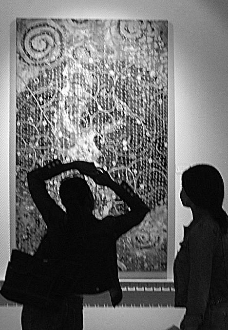 Joyy Norris, junior in LAS, left, and Laclyn Bivings, junior in ACES, look at Possibility IV, a painting by Sandra Ahten on exhibit at Illini Union Wednesday. Norris said it was her favorite painting in the gallery because of intricacies of it and how wel Dan McDonald
