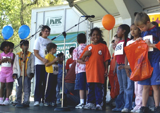 Local children stand on-stage to celebrate the completion of a one mile Fun Run Sunday afternoon at the University of Illinois´ Homecoming Kickoff Celebration at Hessel Park. Tessa Pelias
