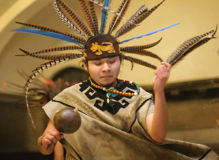 Victor Arroyo, member of the Chicago-based Aztec dance group, Nuahalli, performs a traditional dance at the McKinley Foundation, 809 S. Fifth St., on Saturday night. The performance was presented by Movimiento Estudiantil Chicano de Aztlan. The feather Josh Birnbaum
