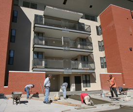 Construction workers lay concrete at the unfinished Campus Property Management apartment building on the corner of Springfield Avenue and First Street. It is still not ready for move-in. Josh Birnbaum
