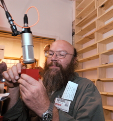 Mike Lehman, graduate student in history, spins the crank of a small music box playing the first song to be broadcasted on WRFU at the radio station in the Independent Media Center on Sunday night. Austin Happel
