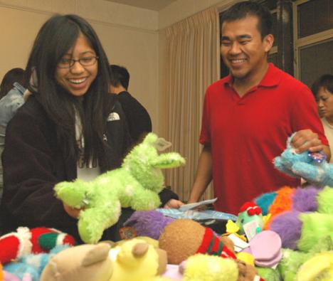 (From left) Seniors Elaine Abasolo, LAS, and Rodel Pedines, Business, pick out a present suitable for a 10-14 year old boy at Operation Christmas Child at the campus YMCA Wednesday. Operation Chirstmas Child is an event where dozens of students come toge Vadim Olen
