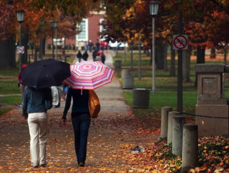 Umbrella-toting students exit Gregory Hall and walk North on the Quad Saturday afternoon. It rained on and off during the day. Peter Hoffman

