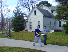 Nicholas Kinsella and Jon Melin, sophomores in FAA, carry landscape architecture models behind Mumford House on the South Quad. Amelia Moore
