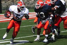 Illinois running back Rashard Mendenhall (5) rushes, chased by defensive back Will Judson (13), during the annual Orange and Blue spring game at Memorial Stadium on Saturday. Mendenhall ran for 44 yards. The Orange won, 20-17. Adam Babcock
