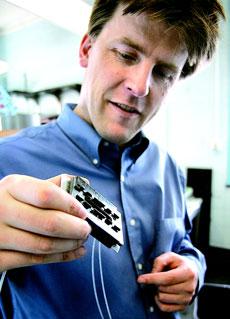Paul Kenis, professor of chemical and biomolecular engineering, shows a fuel cell he developed that does not contain a solid membrane. Instead, it uses laminar flow to separate the fuel and oxidant. Rick Wiltfong
