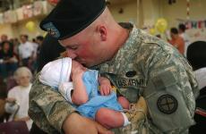 Wheaton resident and medic for the 2nd Battalion, 130th Infantry, Rob Blockinger, kisses his new son Colin, 10 days old, Thursday, for the first time since returning on leave in October 2005. The unit first left in January of 2005. Amelia Moore
