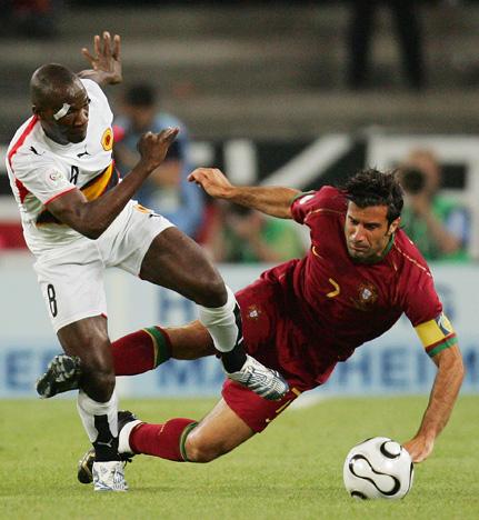 Portugal's Luis Figo is tackles by Angola's Andre during the Group D match between Angola and Portugal at the soccer World Cup 2006 at World Cup Stadium in Cologne, Germany, Sunday, June 11, 2006. The other teams in Group D are Mexico and Iran. (AP Photo/Michael Probst) ** MOBILE/PDA USAGE OUT **
