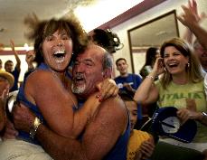 An unindentified woman jumps into the arms of Sammy Ciaramitaro at The Italian American Club of San Pedro in San Pedro, Calif. Tuesday after Italy scored a second goal during a World Cup semifinal match against Germany. Italy won, 2-0 in extra time. The Associated Press
