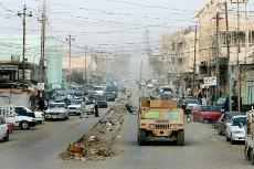 A US military humvee patrols a main street covered with a canopy of electrical wires at the site of the largest U.S. battle in Iraq 40 miles west of Baghdad, Iraq, in Fallujah, in this May 1 file photo. The Associated Press
