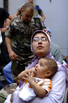 A woman sits with her baby as 66 foreigners are evacuated from the southern Lebanese town of Naqura in a French navy boat under the protection of the French frigate Jean Bart Tuesday . They will be transferred onto another French navy ship Siroco which wi The Associated Press
