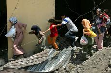 Lebanese residents emerge from shelter as they flee their homes during a lull in the shelling in the village of Aitaroun, Lebanon, Tuesday. The Associated Press
