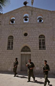 Palestinian security officers patrol past the Latin Patriarchate in the West Bank town of Nablus Monday. The Associated Press
