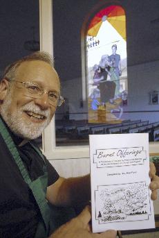 The Rev. Ken Fleck of St. George Church in Tinley Park, Ill., holds up the cookbook he created called "Burnt Offerings" Aug. 10. After 12 years of research and delicious experimentation, Fleck has finished his self-published cookbook made up of 339 recipe The Associated Press
