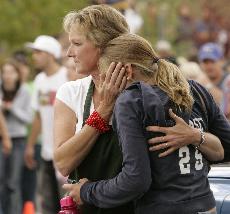 A Platte Canyon High School girl is embraced by a woman after she was evacuated from the school near Bailey, Colo., on Wednesday. A gunman took six girls hostage at the school, holding authorities at bay for hours before he shot and critically wounded a g Ed Andrieski, The Associated Press
