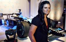 Racecar driver Danica Patrick stands in front of the new No. 7 Motorola car she will drive for the Andretti Green Racing next season after it was unveiled. The Associated Press
