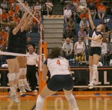 Senior Meghan Macdonald (4) watches as junior Stephanie Alde (9) spikes the ball at a wall of blockers during a game against the University of Dayton at Huff Hall on Tuesday, Sept. 12. John Paul Goguen The Daily Illini
