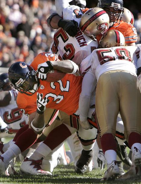 Chicago Bears running back Cedric Benson, left, slices through San Francisco 49er defenders Jeff Ulbrich, (53) and Derek Smith, (50) for a first quarter touchdown during their NFL football game in Chicago, Ill., Sunday, Oct. 29, 2006. AP Photo/Nam Y Huh
