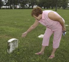 Joline Bennett gestures to areas of Resthaven Cemetery in East Moline, Ill., on Aug. 11, where people were buried from the East Moline State Hospital. The Associated Press
