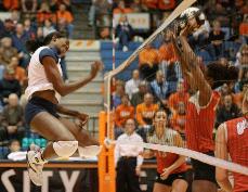 Junior middle blocker Vicki Brown spikes the ball past Ohio State players during the third game in a three game sweep at Huff Hall Friday. John Paul Goguen, The Daily Illini
