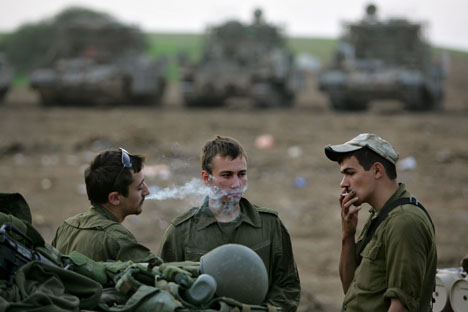 Israeli soldiers smoke at a military staging area near Kibbutz Mefalsim in southern Israel on the border with the Gaza Strip, Sunday, Nov. 26, 2006. A truce meant to end five months of deadly Israeli-Palestinian clashes took hold in the Gaza Strip early S Joseph Lamberson
