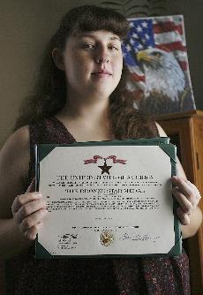 Kentucky National Guard soldier Ashley Pullen shows off her Bronze Star citation at her home in Beaumont, Ky., Nov. 2. The Associated Press
